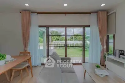 Modern living room with large windows and garden view, featuring stylish furniture and natural light.