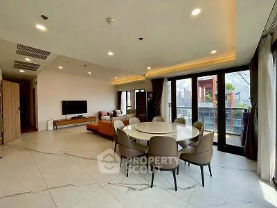 Spacious modern living room with large windows and city view, featuring elegant dining area and stylish decor.