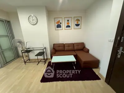 Modern living room with stylish brown sofa, sleek glass desk, and contemporary wall art.