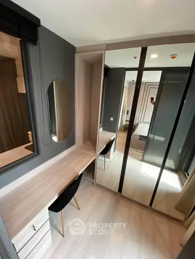 Modern bedroom with stylish mirrored wardrobe and sleek desk area