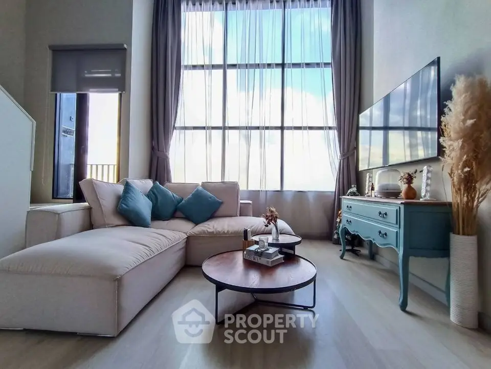 Stylish living room with large windows, modern sofa, and elegant decor in a bright, airy space.