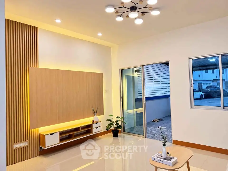 Modern living room with stylish lighting and sliding glass doors leading to a patio.