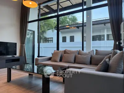 Spacious living room with modern decor and large windows offering natural light