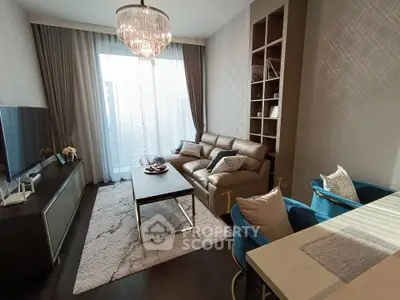 Elegant living room with modern decor and large window, featuring a plush sofa and stylish chandelier.