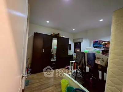 Cozy bedroom with wooden flooring and ample storage space in a modern apartment.