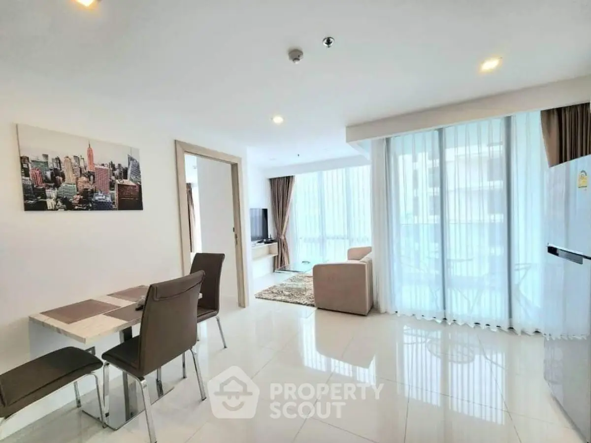 Spacious modern living room with dining area and large windows in a bright apartment