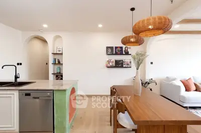 Modern open-plan kitchen and dining area with stylish lighting and contemporary decor.