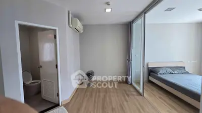 Modern apartment with bedroom and bathroom, featuring wooden flooring and air conditioning.