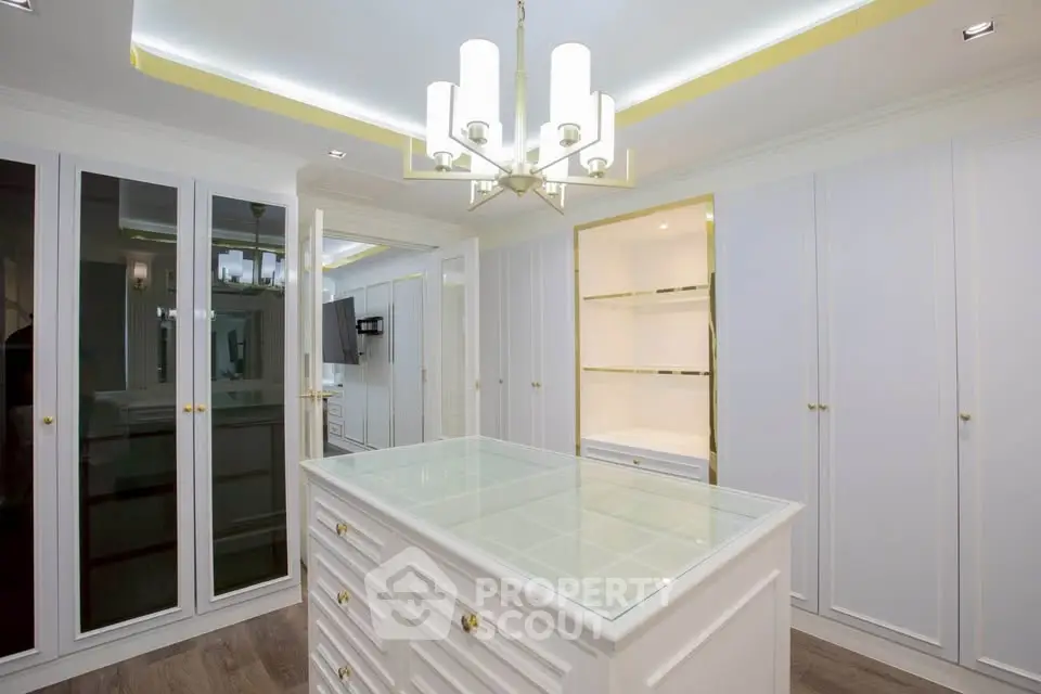 Luxurious walk-in closet with elegant lighting and ample storage space