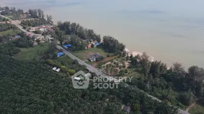 Scenic aerial view of coastal real estate with lush greenery and oceanfront access.