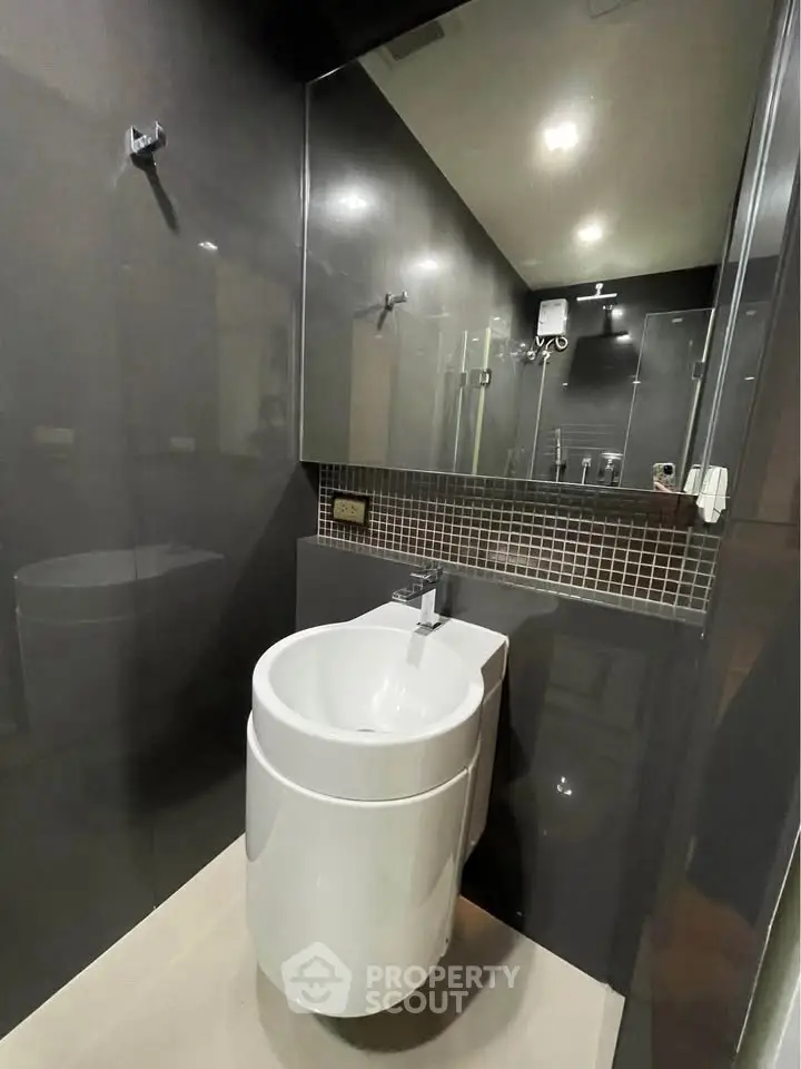 Modern bathroom with sleek fixtures and stylish black tile design.
