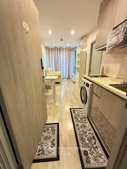 Modern apartment interior with open kitchen and cozy living area, featuring stylish decor and natural light.