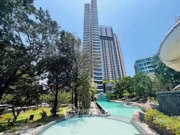 Luxurious high-rise building with stunning pool and lush garden view.