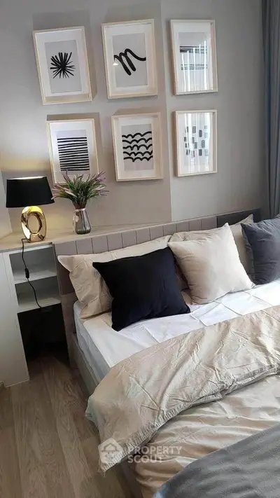 Stylish bedroom with modern decor and framed art, featuring cozy bedding and ambient lighting.