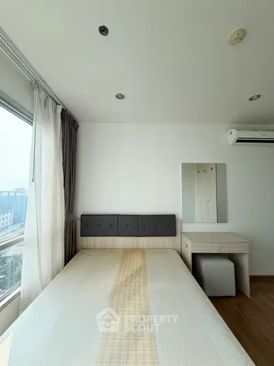 Bright and airy bedroom with modern furnishings and large window view.