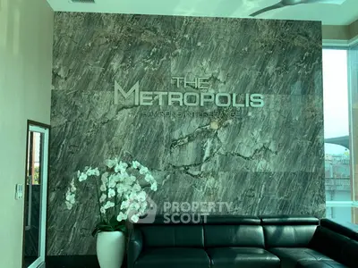 Luxurious modern living room with elegant marble wall and stylish black leather sofa at The Metropolis.