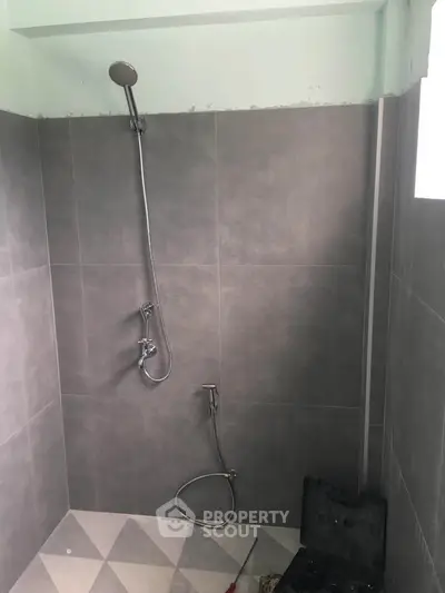 Modern bathroom with sleek shower fixtures and tiled walls, perfect for a contemporary home.