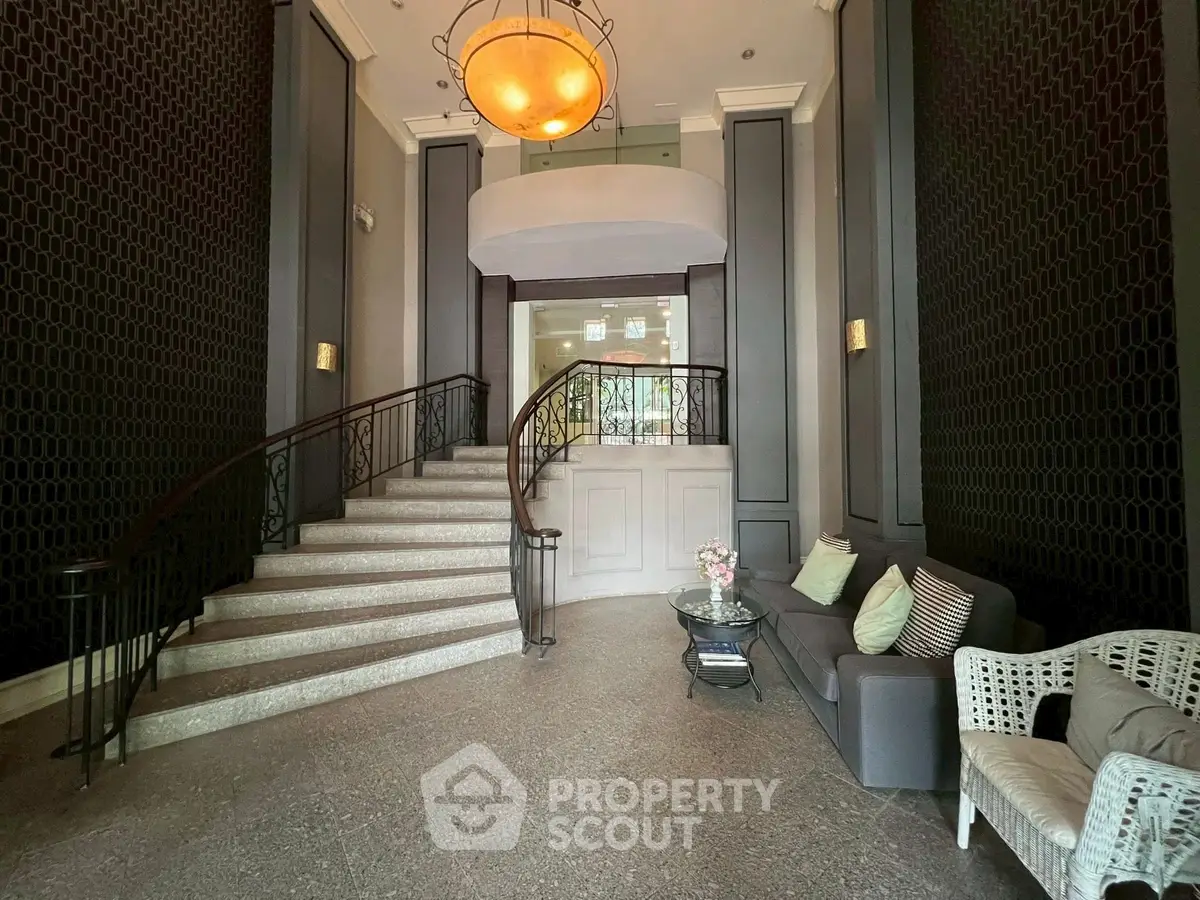 Elegant entrance with grand staircase and cozy seating area in luxury property