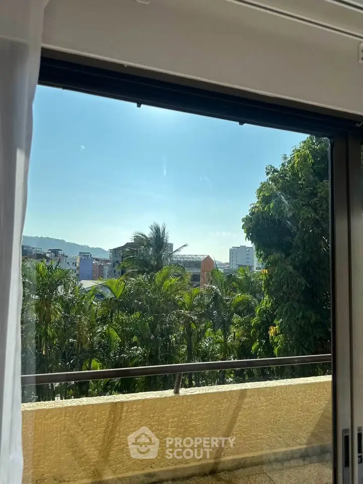 Stunning view from a balcony overlooking lush greenery and cityscape.