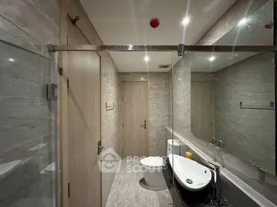 Modern bathroom with sleek design, featuring a glass shower and stylish fixtures.