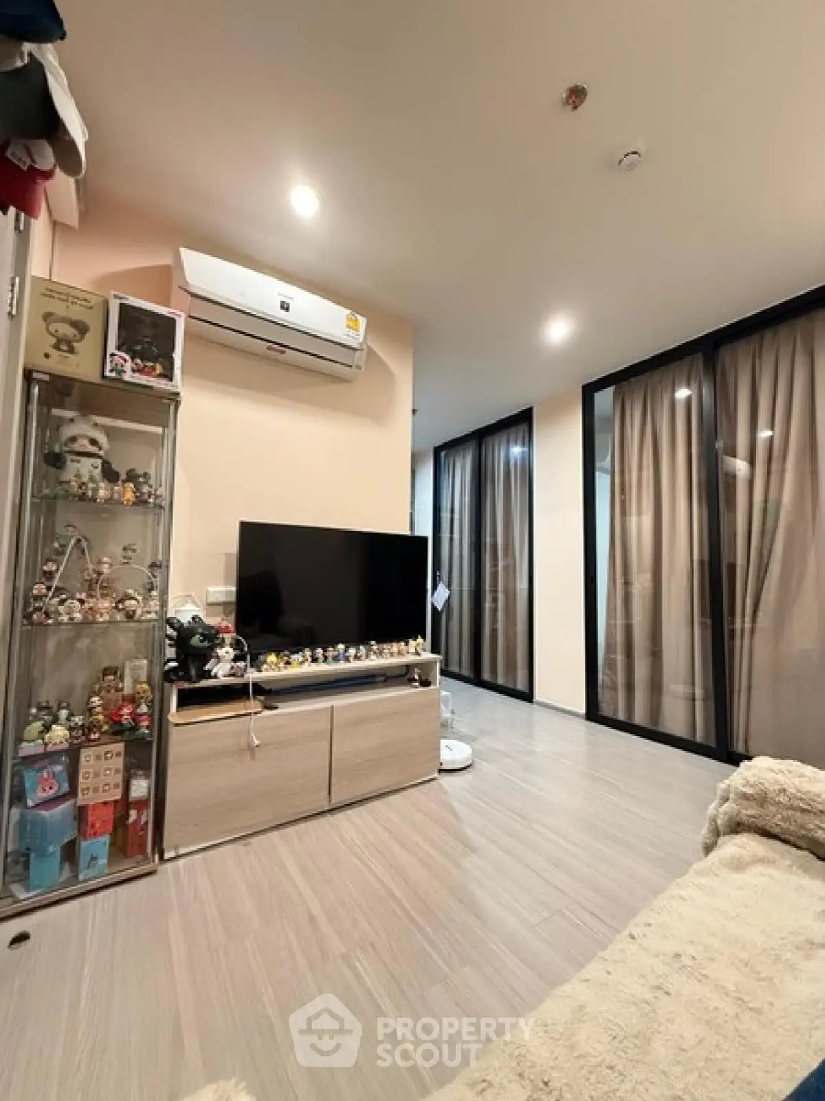 Modern living room with sleek decor and glass display cabinets in a cozy apartment.