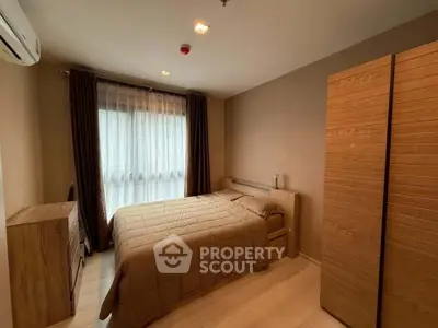 Cozy bedroom with wooden furniture and large window for natural light.