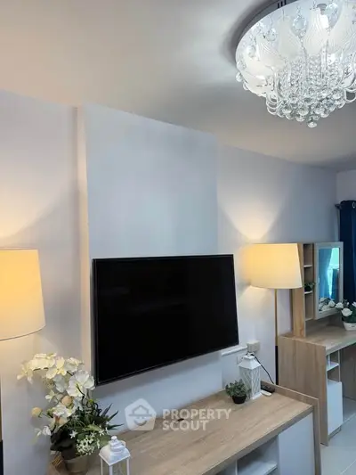 Modern living room with elegant chandelier and sleek TV setup