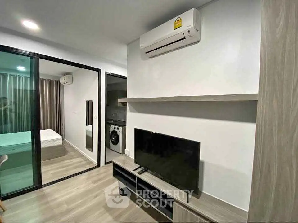 Modern apartment interior with air conditioning, TV, and washing machine in a compact layout.