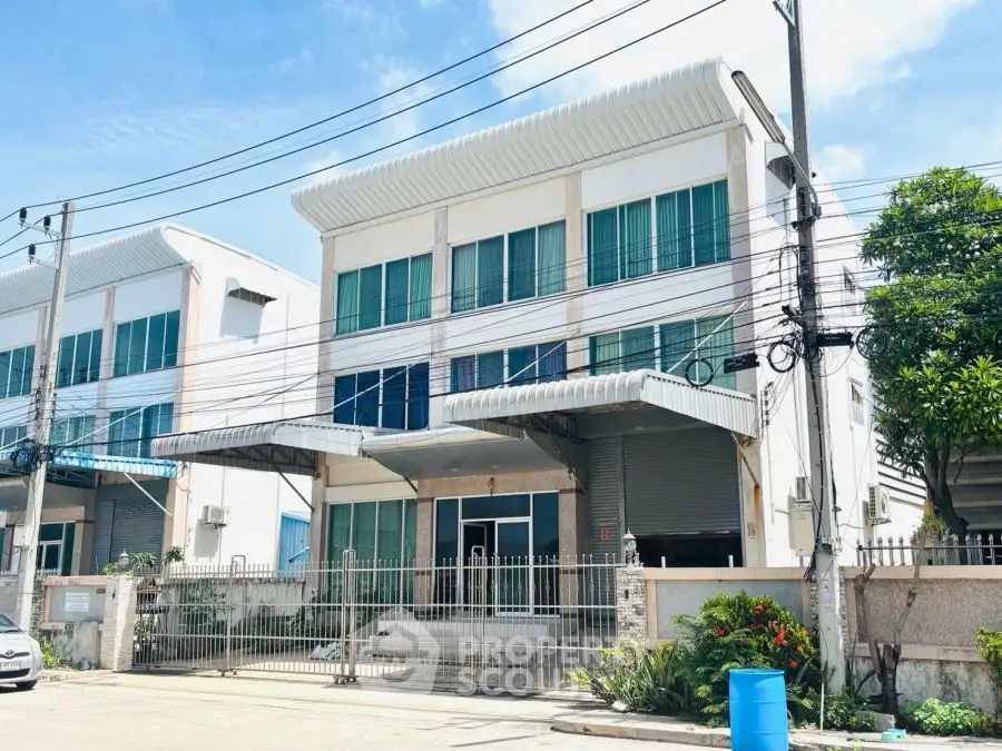 Modern commercial building with gated entrance and large windows, ideal for business use.