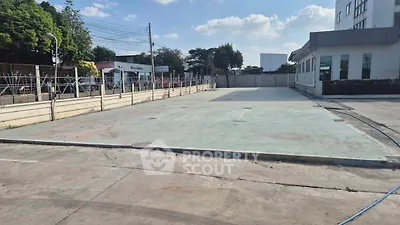 Spacious industrial property with open concrete yard and secure fencing.