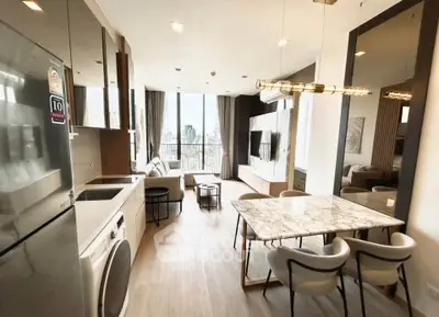 Modern open-plan living room with city view, featuring sleek kitchen and stylish dining area.
