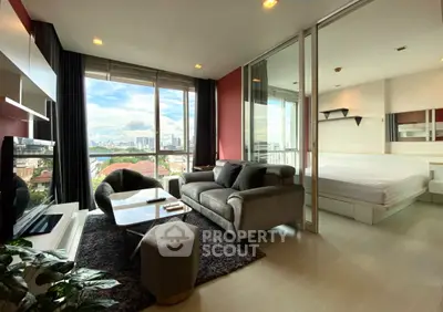 Modern living room with city view, cozy sofa, and stylish decor in a high-rise apartment.