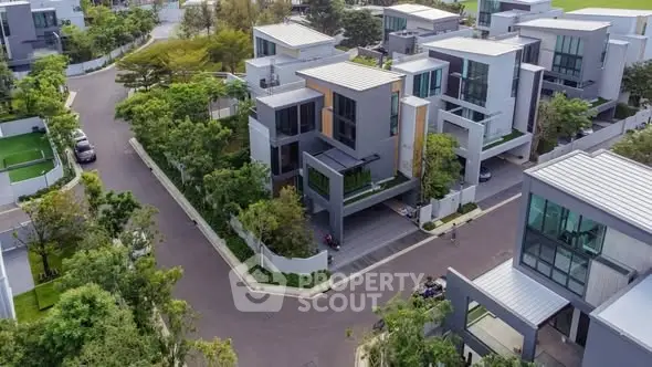 Modern luxury residential complex with lush greenery and contemporary architecture.