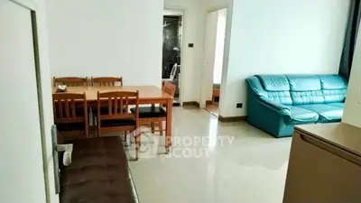 Spacious living room with dining area and modern furniture in a bright apartment.