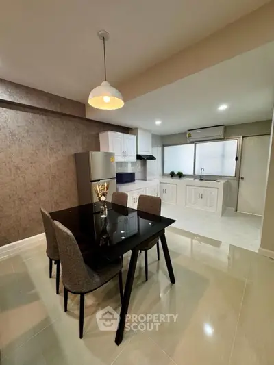 Modern kitchen with dining area featuring sleek design and contemporary lighting.
