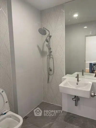 Modern bathroom with sleek shower and stylish sink in contemporary design.
