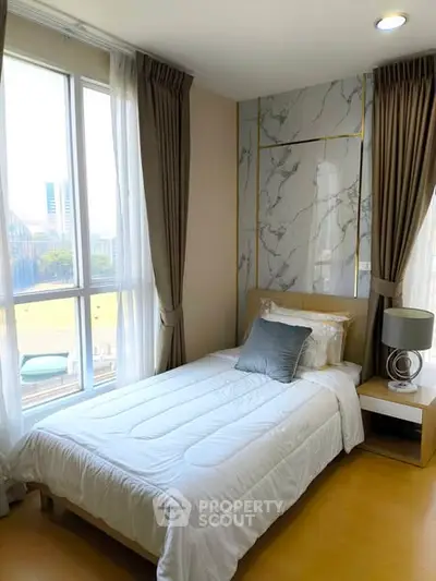 Modern bedroom with large window and elegant decor in a high-rise apartment.