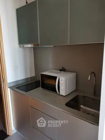Modern compact kitchen with sleek cabinetry and built-in appliances, perfect for urban living.