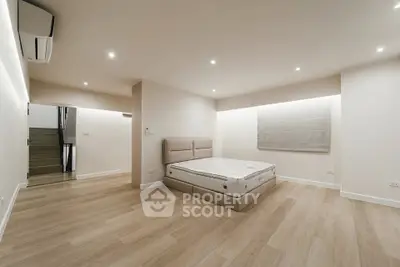 Spacious modern bedroom with minimalist design and wooden flooring