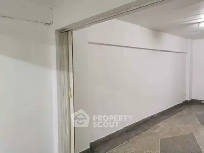 Spacious interior with white walls and tiled flooring, ideal for versatile use.