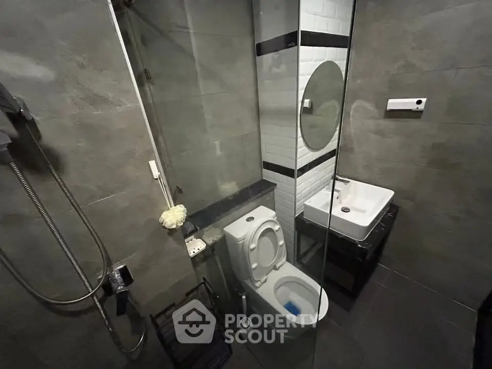 Modern bathroom with sleek design, featuring a glass shower and contemporary fixtures.