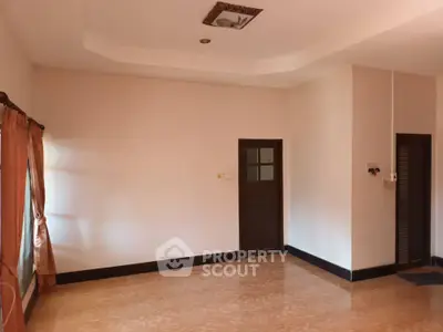 Spacious empty room with tiled floor and natural light, ideal for customization.