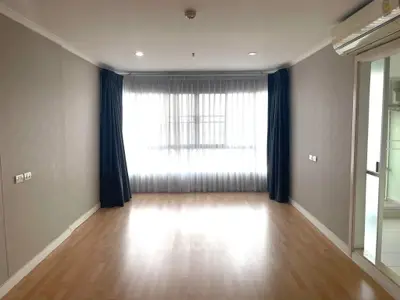 Spacious empty room with large window and wooden flooring, ideal for customization.