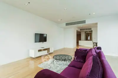 Spacious modern living room with purple sofa and wall-mounted TV, ideal for relaxation.