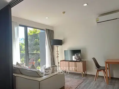 Modern living room with balcony, stylish furniture, and natural light in a contemporary apartment.