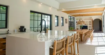 Spacious modern kitchen with open layout and elegant dining area, featuring natural light and stylish decor.