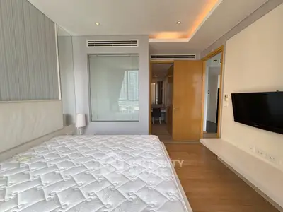 Modern bedroom with sleek design and wall-mounted TV in luxury apartment