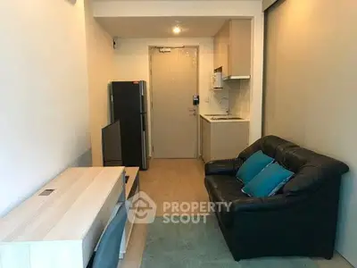 Cozy modern living room with compact kitchen and sleek furniture in a stylish apartment.