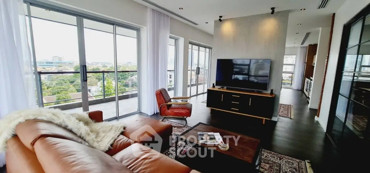 Spacious living room with modern decor and large balcony offering stunning city views.