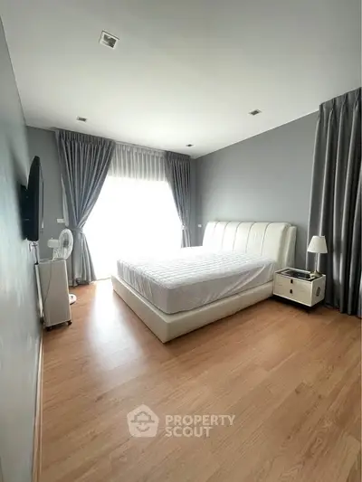 Spacious bedroom with modern decor and natural light